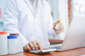 close up on pharmacy doctor trying to search feature of medicine on laptop concept