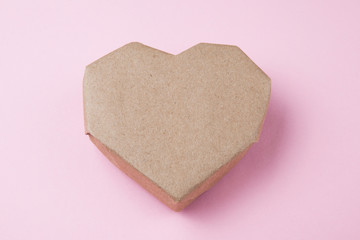 Close-up, an old paper heart on a pink.