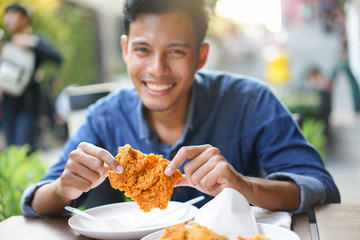 close up focus man hand hold and showing fried chicken meal for eat at restaurant bar,fast food...