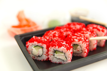 Sushi rolls with salmon and caviar on a white wooden table