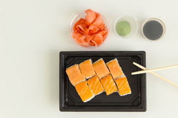 top view of sushi rolls with ginger on a white wooden table