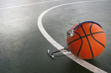 orange basketball with stethoscope for doctor diagnosis in sport indoor gymnasium background