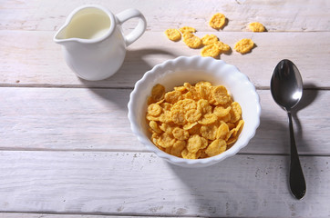 Corn Flakes cereal in a bowl and glass with milk. Morning breakfast.