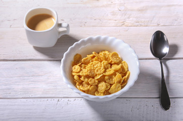 Corn Flakes cereal in a bowl and cap with espresso coffee. Morning breakfast.