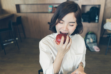 Beautiful modern business woman bite the big apple in co working spaces.