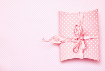 Festive gift on pink pastel background, present box for celebration card, selective focus, toned