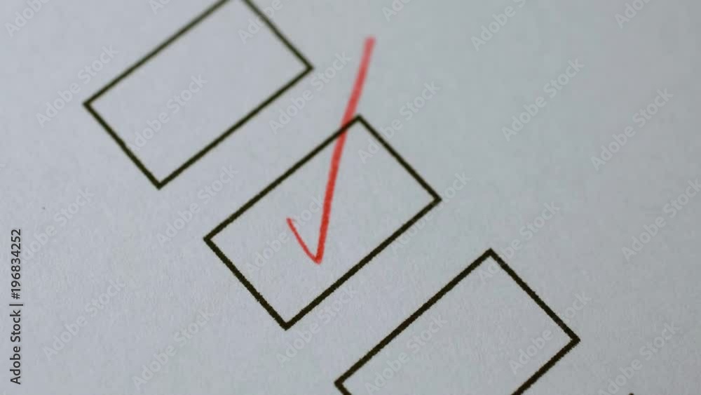 Poster marker puts a tick in the box on white paper - close-up