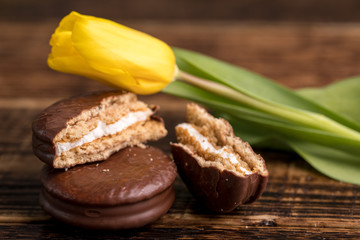 Chocolate biscuits with a delicate filling and a tulip flower. A gift for Valentine's Day. Macro.