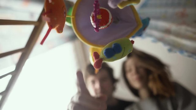 happy father and mother play with baby in crib kid point of view.