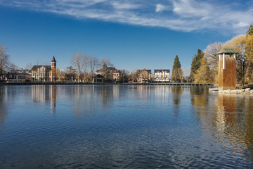 Mirror effect water reflection on Puigcerdà lake landmark on a blue sunny sky