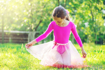 Beautiful preteen girl doing gymnastics and stretching in the city park on  summer sunset