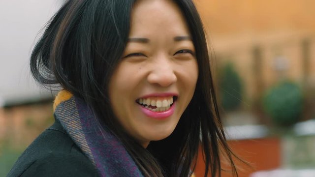 Portrait of beautiful asian woman laughing outdoor- slow motion