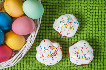 Fototapeta na wymiar Colorful easter eggs in basket and sweet muffin cupcakes. Easter background. Spring religious holiday easter concept