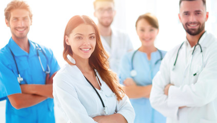 Fototapeta premium Attractive female doctor with medical stethoscope in front of medical group