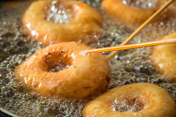 Closeup of frying tasty and homemade donuts on fresh oil