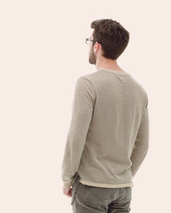 Rear view. Full length. Young man in gray sweater