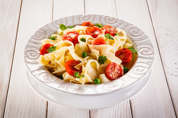 Pasta with vegetables on wooden table