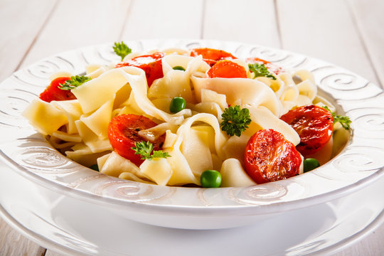 Pasta with vegetables on wooden table