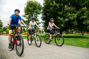 Healthy lifestyle - people riding bicycles in city park 