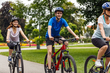 Obraz premium Healthy lifestyle - people riding bicycles in city park 