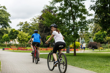 Healthy lifestyle - people riding bicycles in city park 