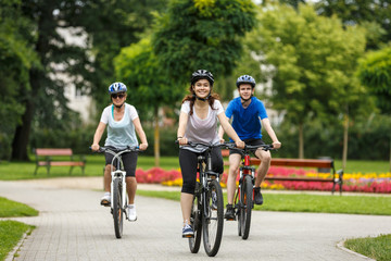 Naklejka premium Healthy lifestyle - people riding bicycles in city park 