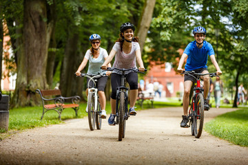 Obraz premium Healthy lifestyle - people riding bicycles in city park 