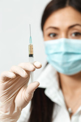 The cosmetician holds a syringe with a preparation