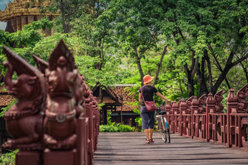 Woman walking across a bridge in Ancient Siam, Thailand