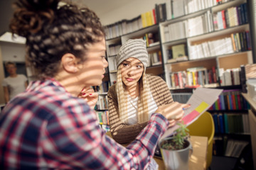 Two beautiful young student girls studying for the big exam in the sunny library.