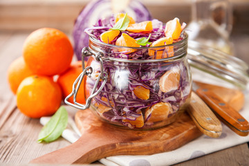 Red cabbage tangerines and pine nuts salad. Selective focus. Copy space.