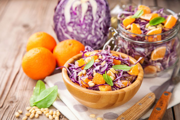 Red cabbage tangerines and pine nuts salad. Selective focus. Copy space.