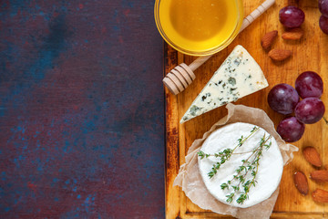 Cheese, honey and fruit on a table. Selective focus. Top view. Copy space.