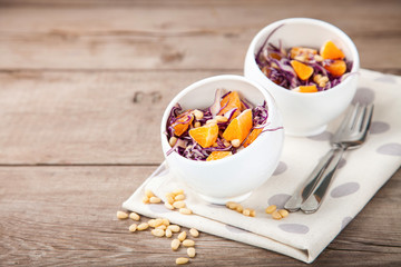 Red cabbage tangerines and pine nuts salad. Selective focus. Copy space.