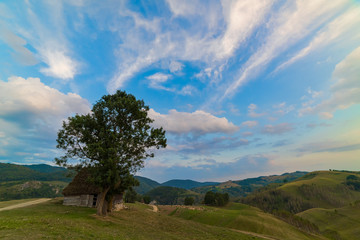 Fototapeta na wymiar Beautiful mountain landscape with and old house, trees and a cloudy morning sky, Dumesti, Salciua, Apuseni, Romania