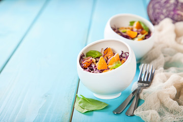 Red cabbage tangerines and pine nuts salad. Selective focus. Copy space.