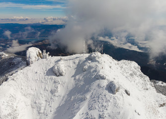 Fototapeta na wymiar Ceahlau Toaca weather station on top of the mountain. Romania, winter scene