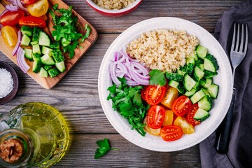 Healthy Quinoa Tabbouleh Salad bowl with fresh cucumbers, tomatoes and red onions
