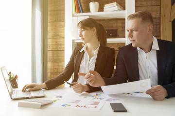 Business people discussing the charts and graphs showing the results of their successful teamwork at office