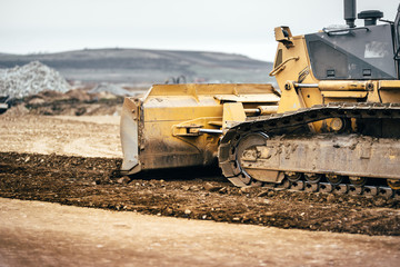 highway construction site development with bulldozer moving earth, soil and leveling ground