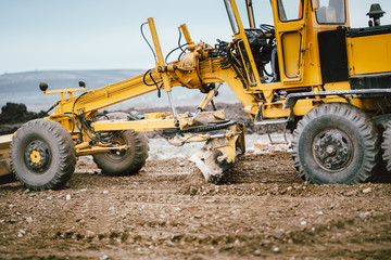 highway construction site development with motor grader moving earth, soil © aboutmomentsimages
