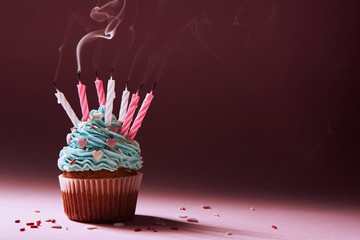 muffin with cream and extinguished candle. the concept of the end of the celebration.