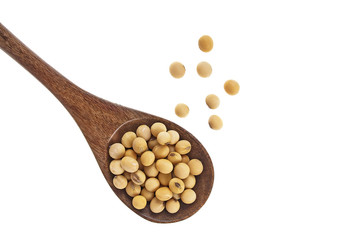Soybeans in wooden spoon on a white background. Top view.