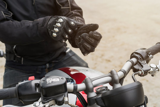 Fototapeta Biker with jacket wearing protect glove and riding motorbike