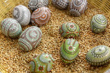 Sorbische Ostereier mit Wachstechnik selbst gestaltet in einem Bastkorb auf Weizen