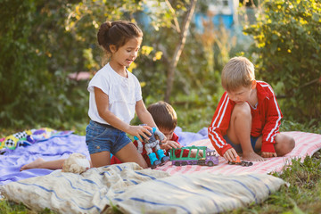 two boys and a girl playing with toys in nature