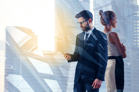 Businessman and woman using smartphone in city