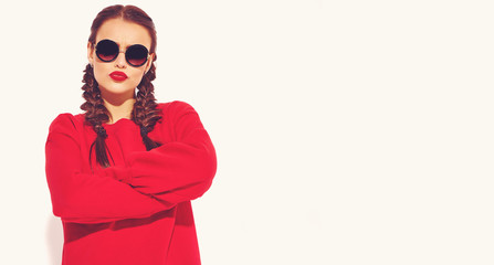 Portrait of young happy smiling woman model with bright makeup and colorful lips with two horns and sunglasses in summer red clothes isolated on white. Сrossed arms