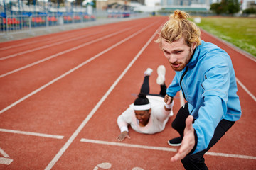 Young man pulling oversized female down racetrack towards finish line