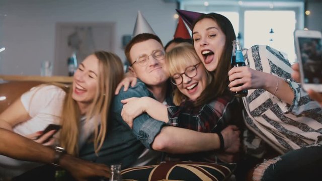 European woman hugs friends on her birthday party. Happy multi ethnic youth share birthday celebration together. 4K.